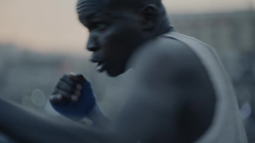 A boxer punches the air at sunset