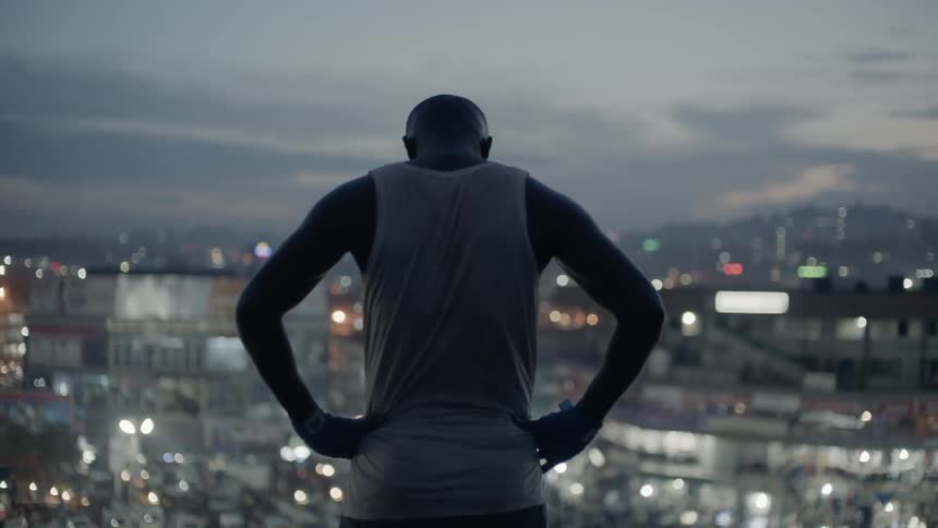 Man stands on a building rooftop at dusk
