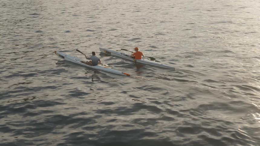 Two people kayak on a large body of water