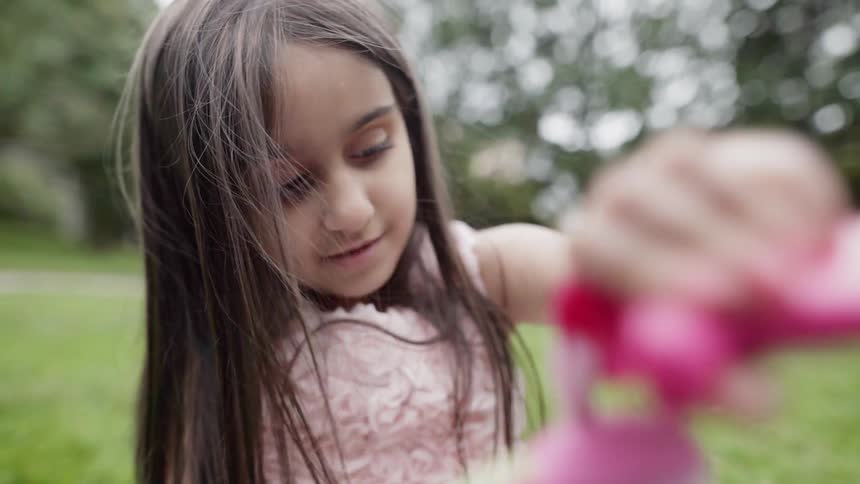 Close up of a sweet young girl focused on playing with a toy.