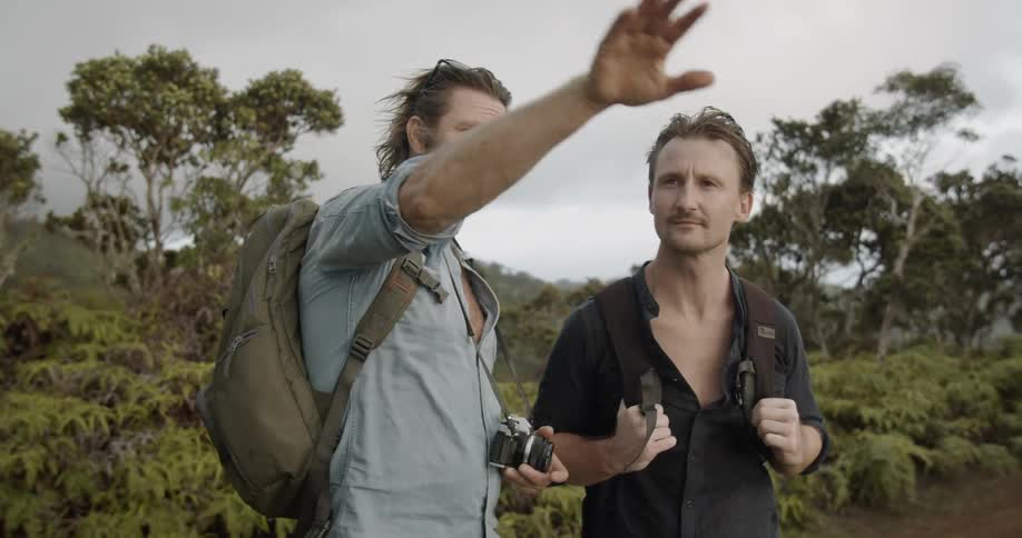 Two men talk while hiking