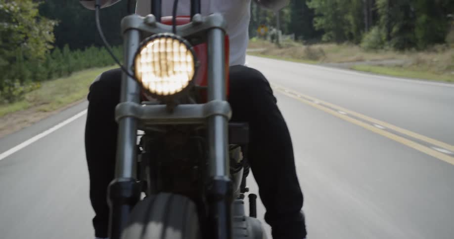 Man rides motorcycle down highway