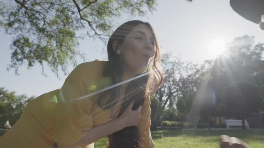 A young woman looking up with a cheerful expression during outdoor picnic.