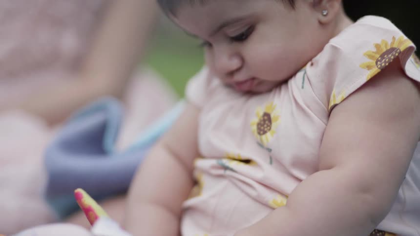 Close up of a sweet baby intently focused on playing with toys.