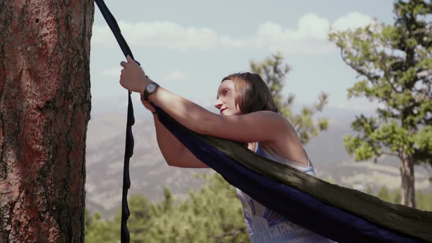 Woman ties hammock to trees