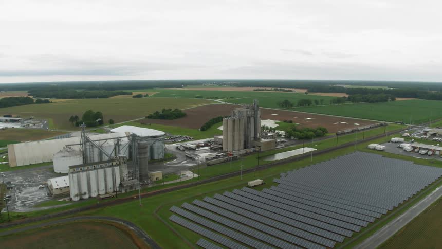 Solar panels and silos sit on a farm