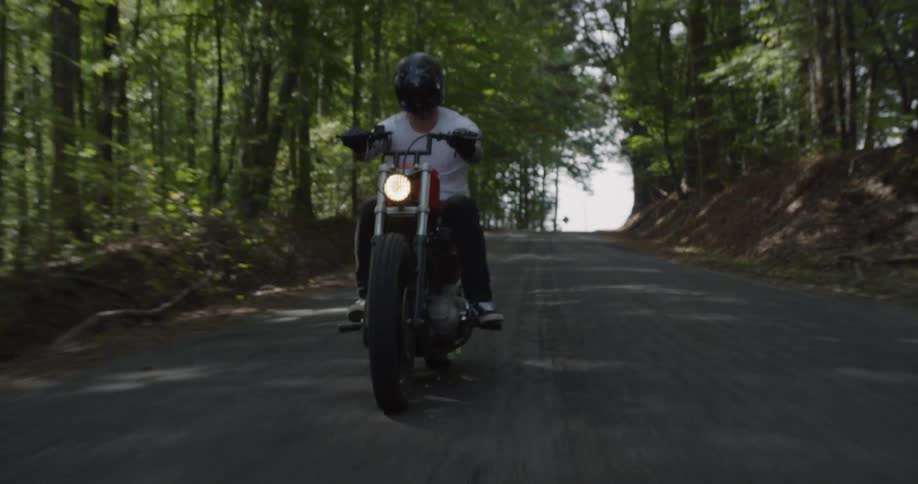 Man rides motorcycle down highway