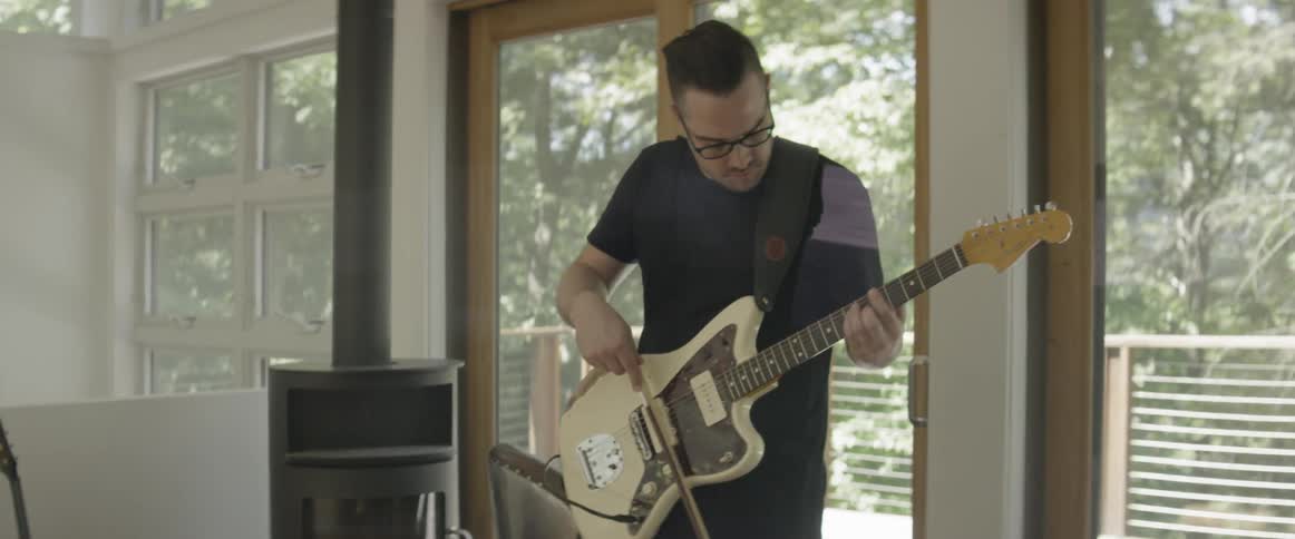 Man plays guitar with violin bow