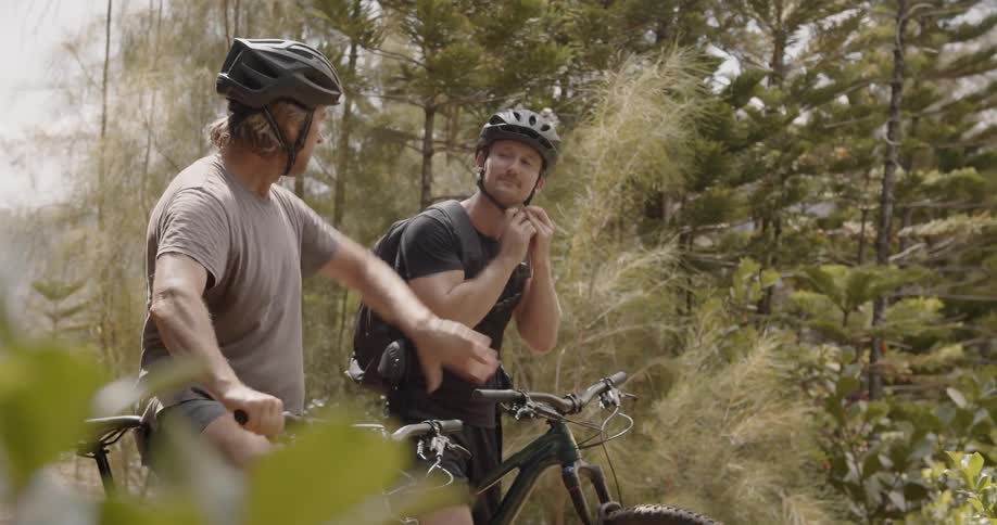 Two men bicycle in a forest