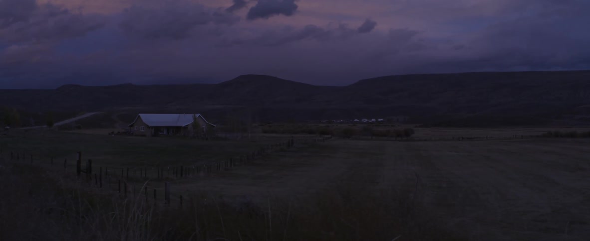 A farmhouse field at night