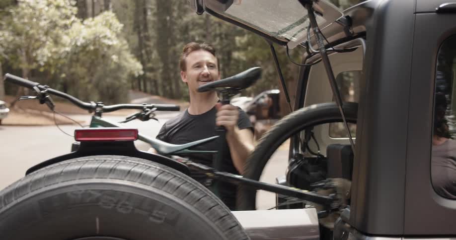 Man unloads bicycle from car