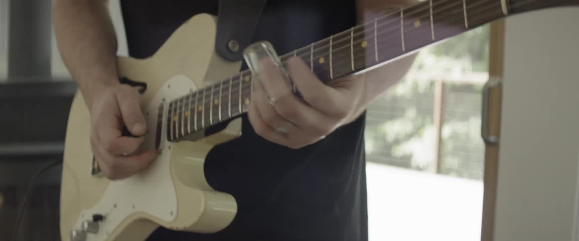 Man plays a guitar indoors