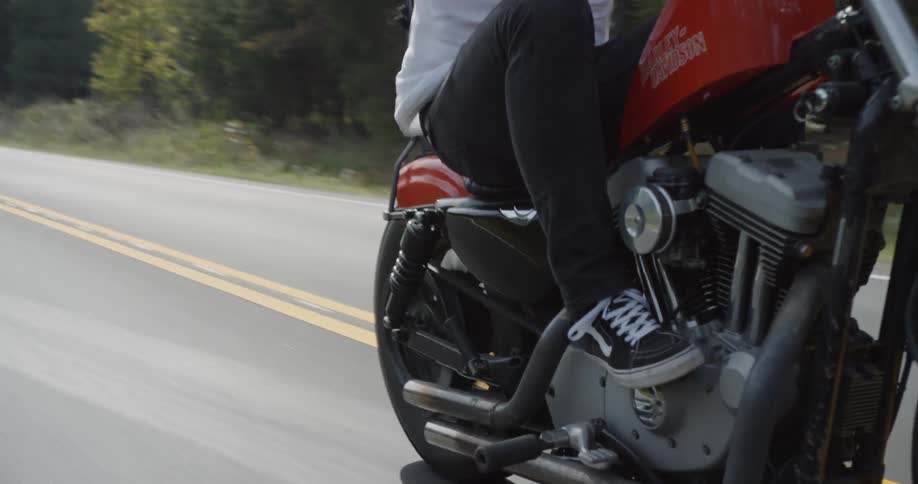 A motorcyclist rides on a rural road