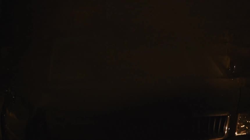 Man and woman talk in a parked car at night