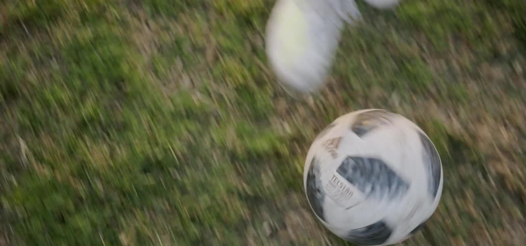 Person is rolling and kicking soccer ball in field