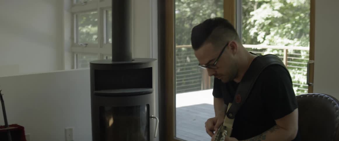 Man plays a guitar indoors