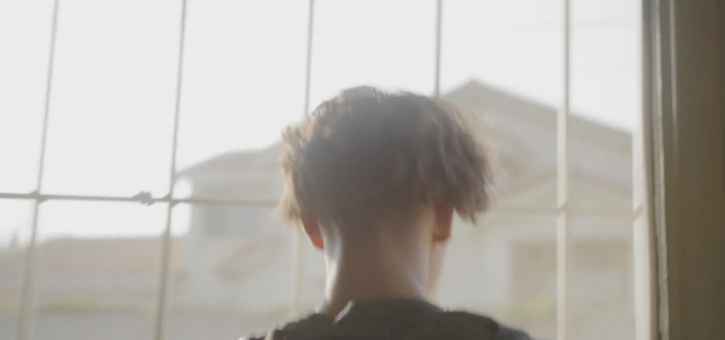 Boy puts on backpack and leaves his house