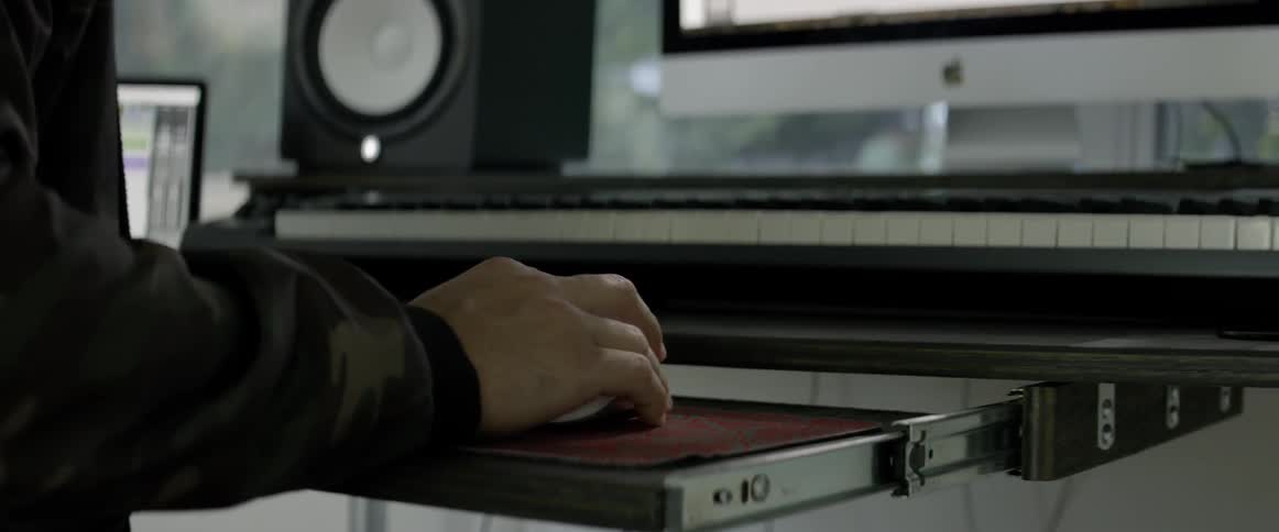 A man sits down at a studio computer