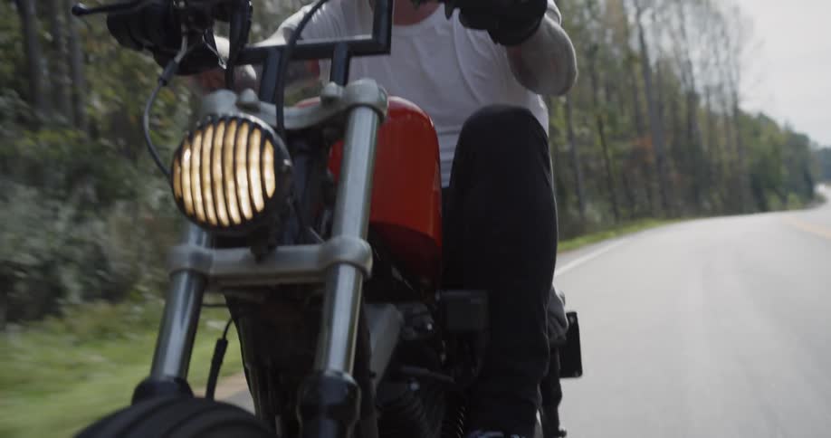 A man motorcycles on a rural road