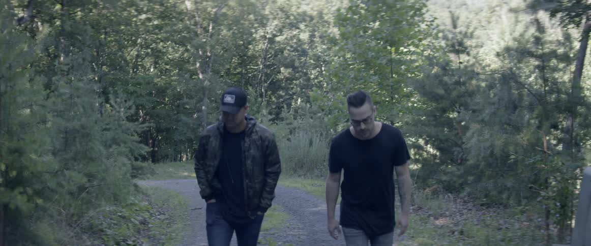 Two men walk in a forest