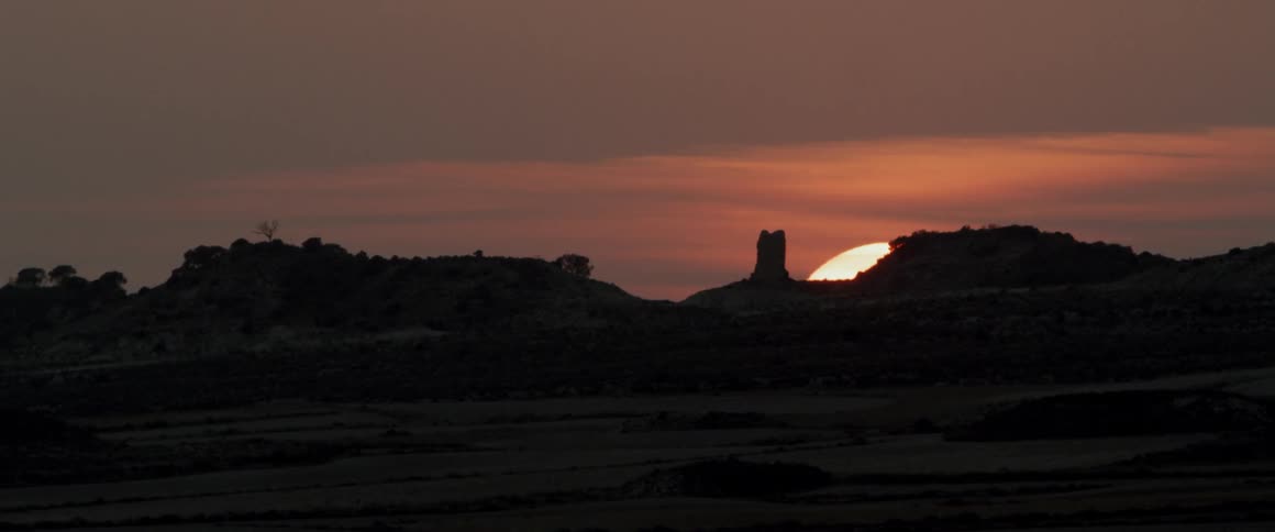 The sun sets behind the canyon