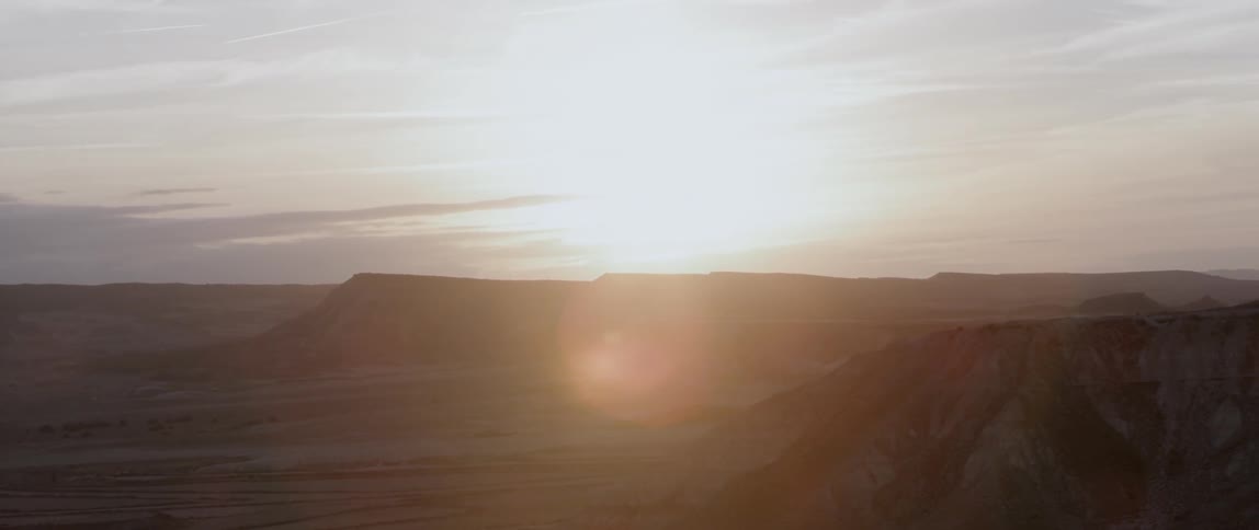The bright sun rises behind the mountain