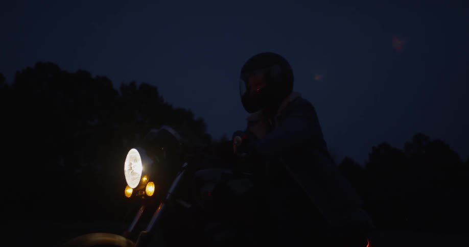 A motorcyclist rides in the dark