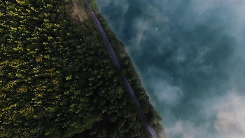 Clouds float over a forest and lake