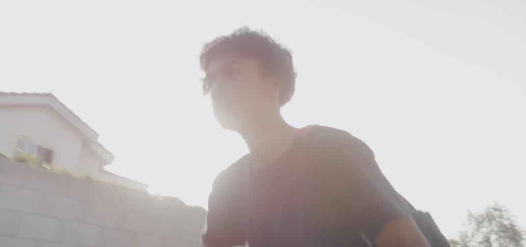A teenager bicycles on a sunny day