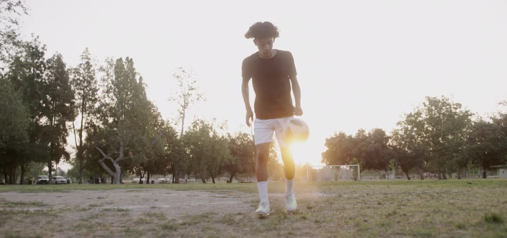 Boy practices dribbling soccer ball
