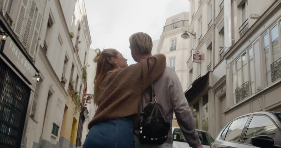 A man and woman embrace on the street