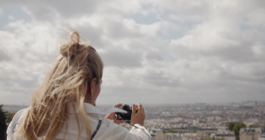 Woman holds a camera as she takes a photo