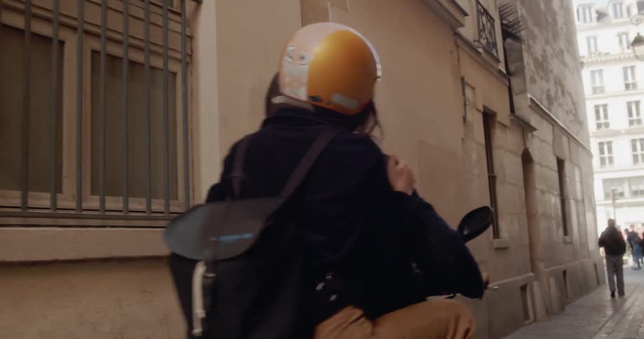 A man and woman ride on a scooter