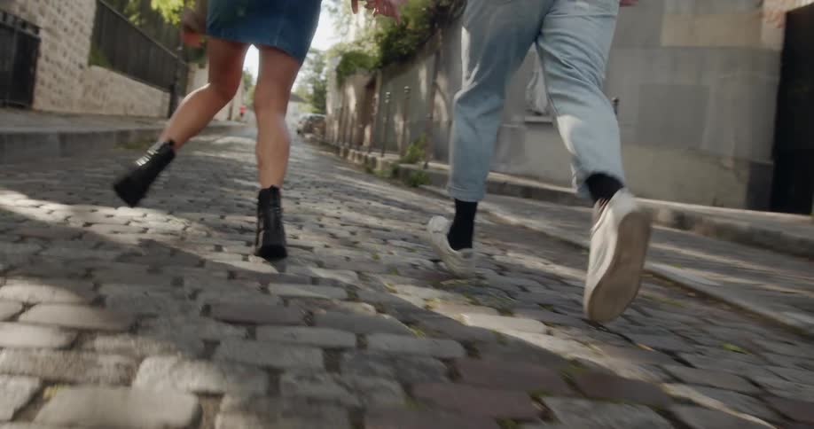 Man and woman run on a city sidewalk