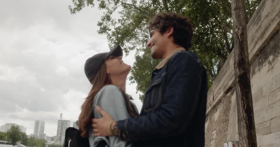 Couple embrace on urban sidewalk