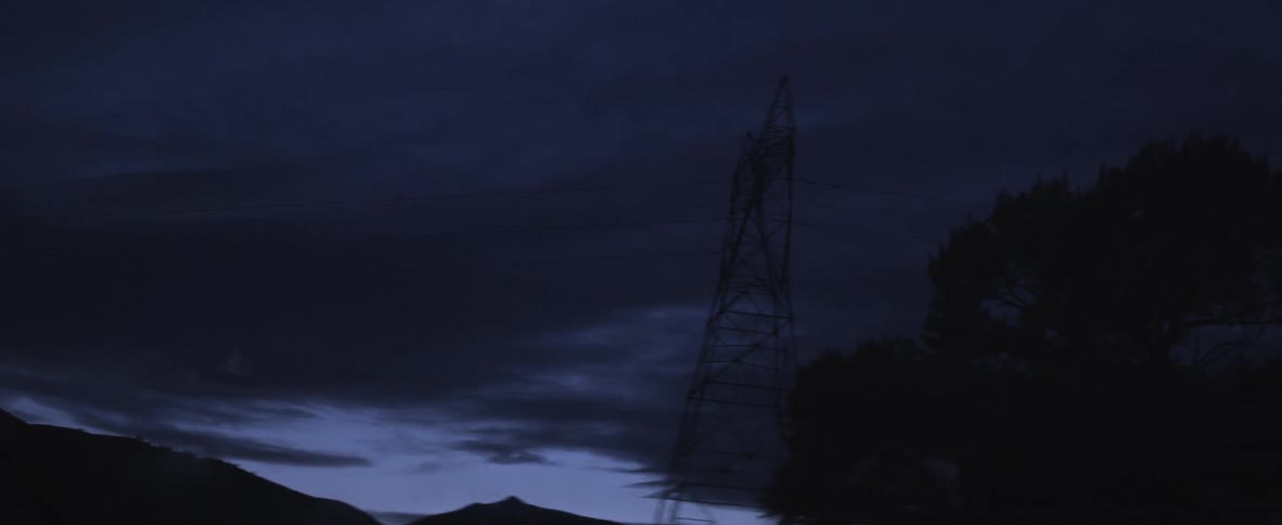 A tall power line at night