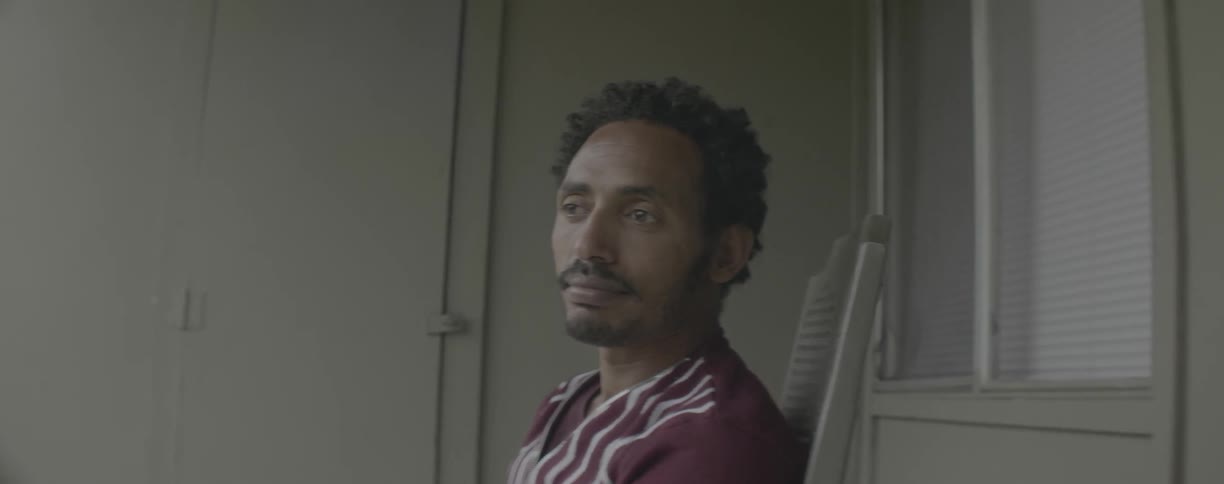 A man sits solemnly in a chair