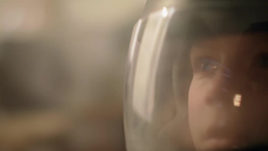 A young boy watches television while wearing a helmet
