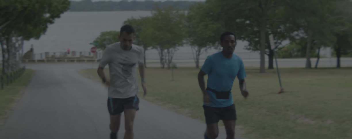 Two men jog near a lake