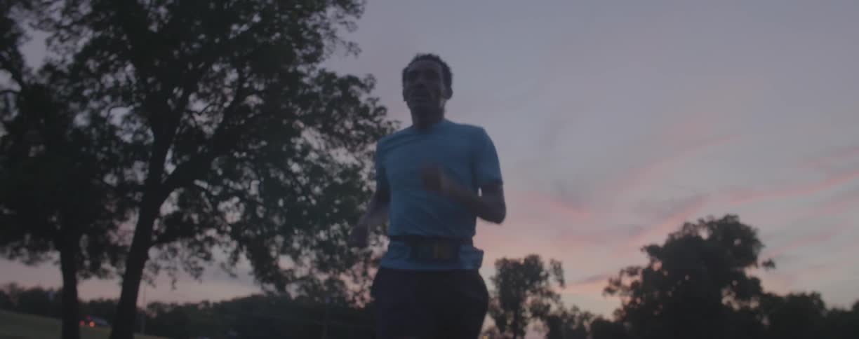 A man jogs outside at sunset
