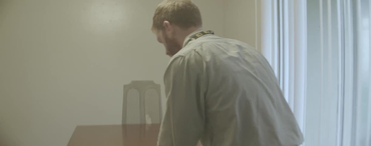 Two men look at a document in a dining room