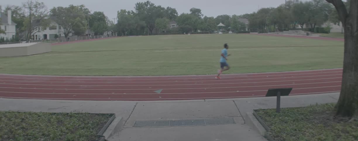 Man is running on track around a field