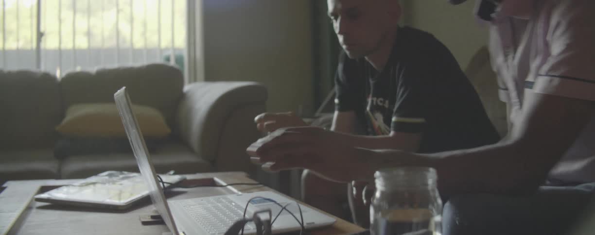 Men work on a laptop at a table