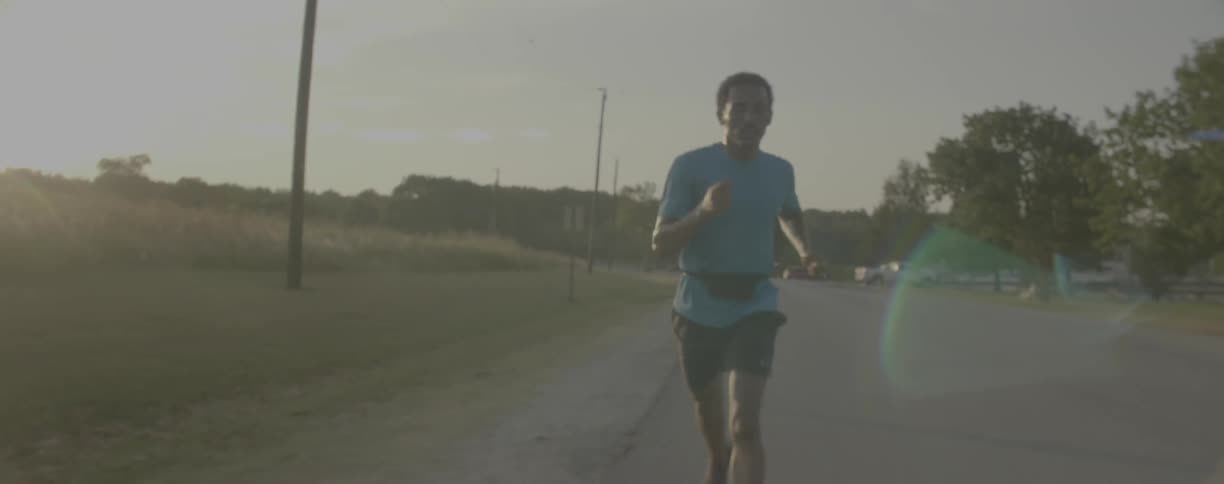 A man jogs on a rural road
