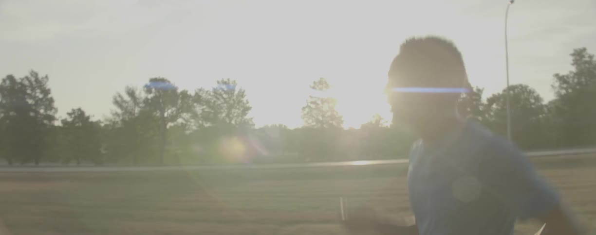 Man runs near the highway under the bright sun