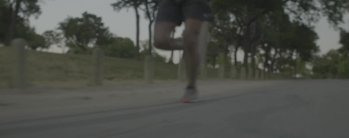 Man runs down the road near the trees