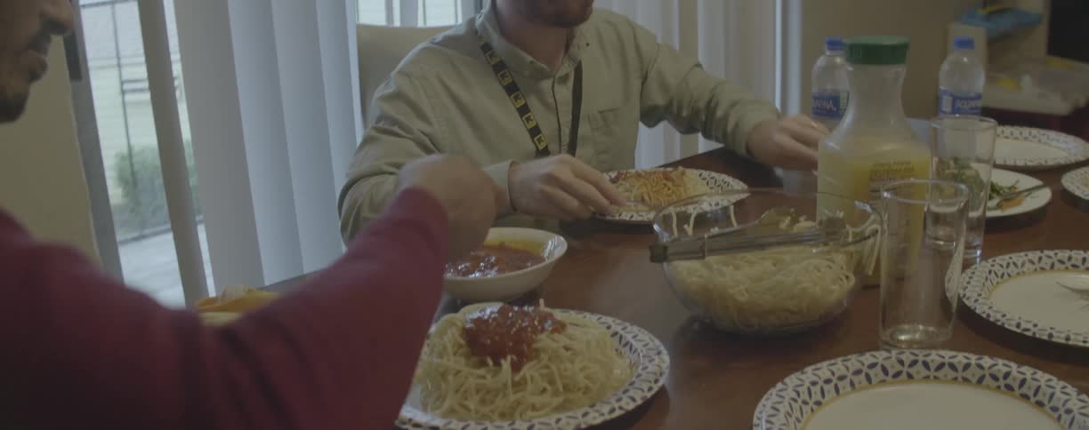 A family eats spaghetti at home