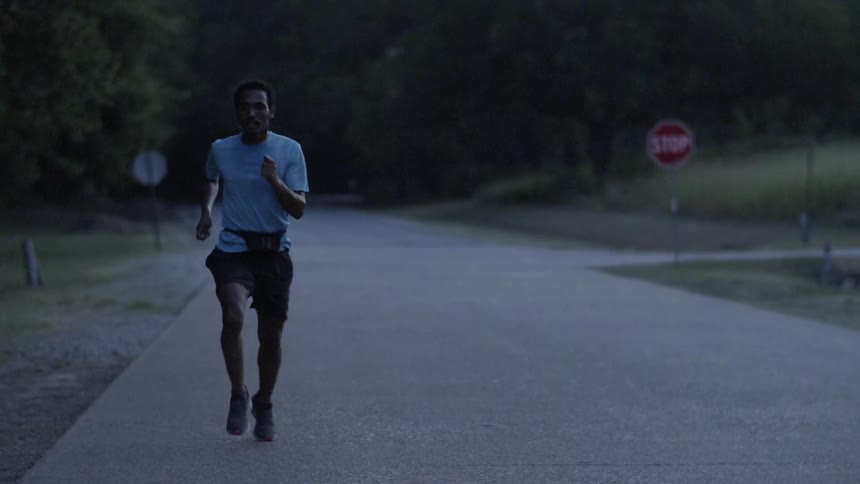 Man is jogging on road at dusk