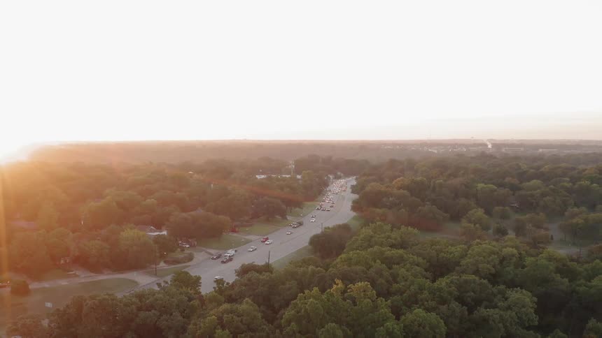 Cars are traveling on highway as sun sets