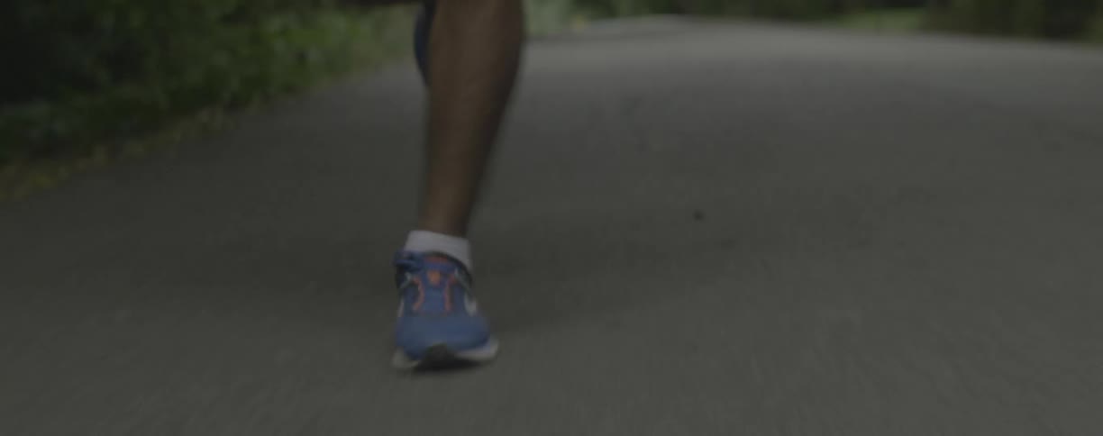A runner jogs on a paved path
